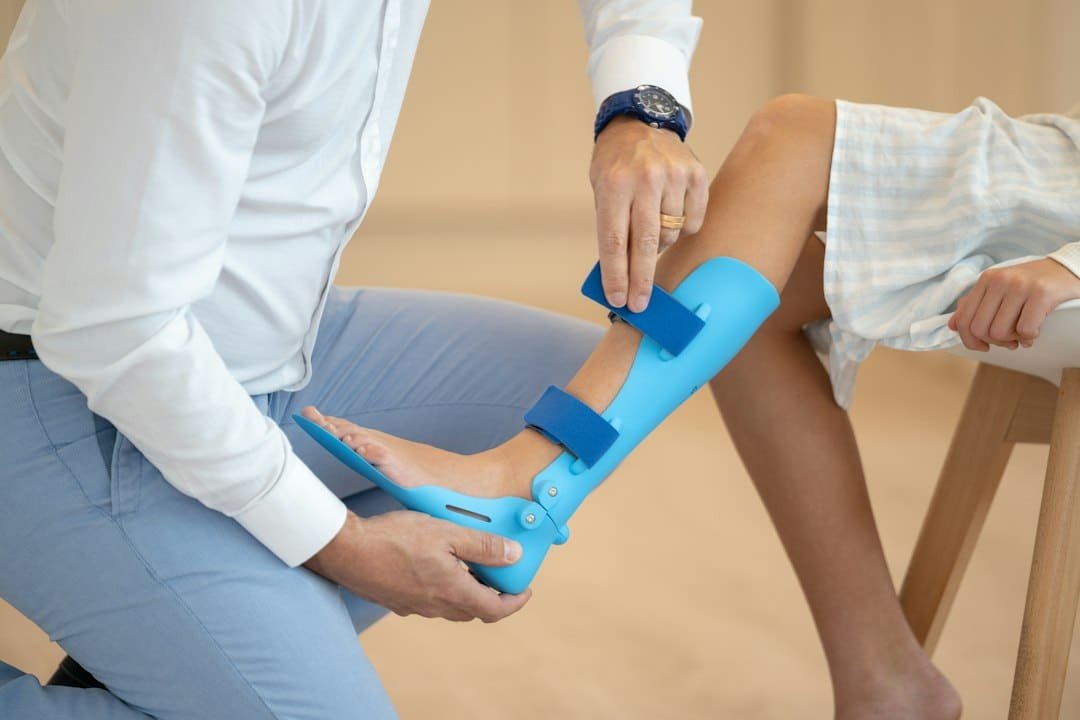 Custom Bracing & Orthotics 2 a person sitting on a chair with a foot in a cast